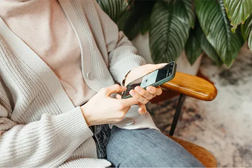 Woman seated in a chair using her mobile phone